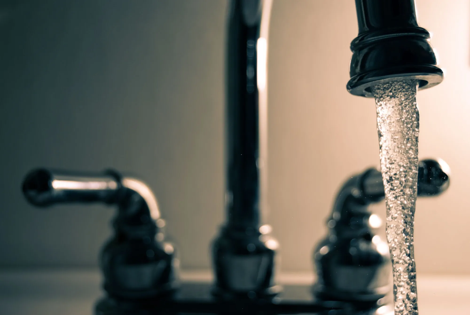 Acqua limpida che scorre dal rubinetto di una cucina